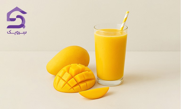 لیوان آب‌انبه تازه کنار انبه خردشده