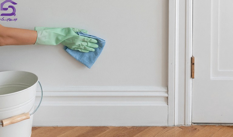 تمیز کردن دیوار؛ روشهای موثر نظافت انواع دیوار با شوینده تمیز کردن دیوار با دستمال و دستکش در کنار سطل آب