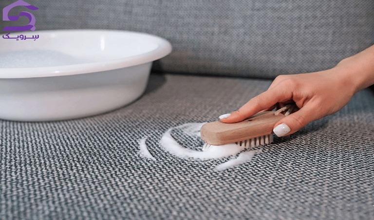 تمیز کردن لکه مبل پارچه‌ای با برس نرم و کف شوینده